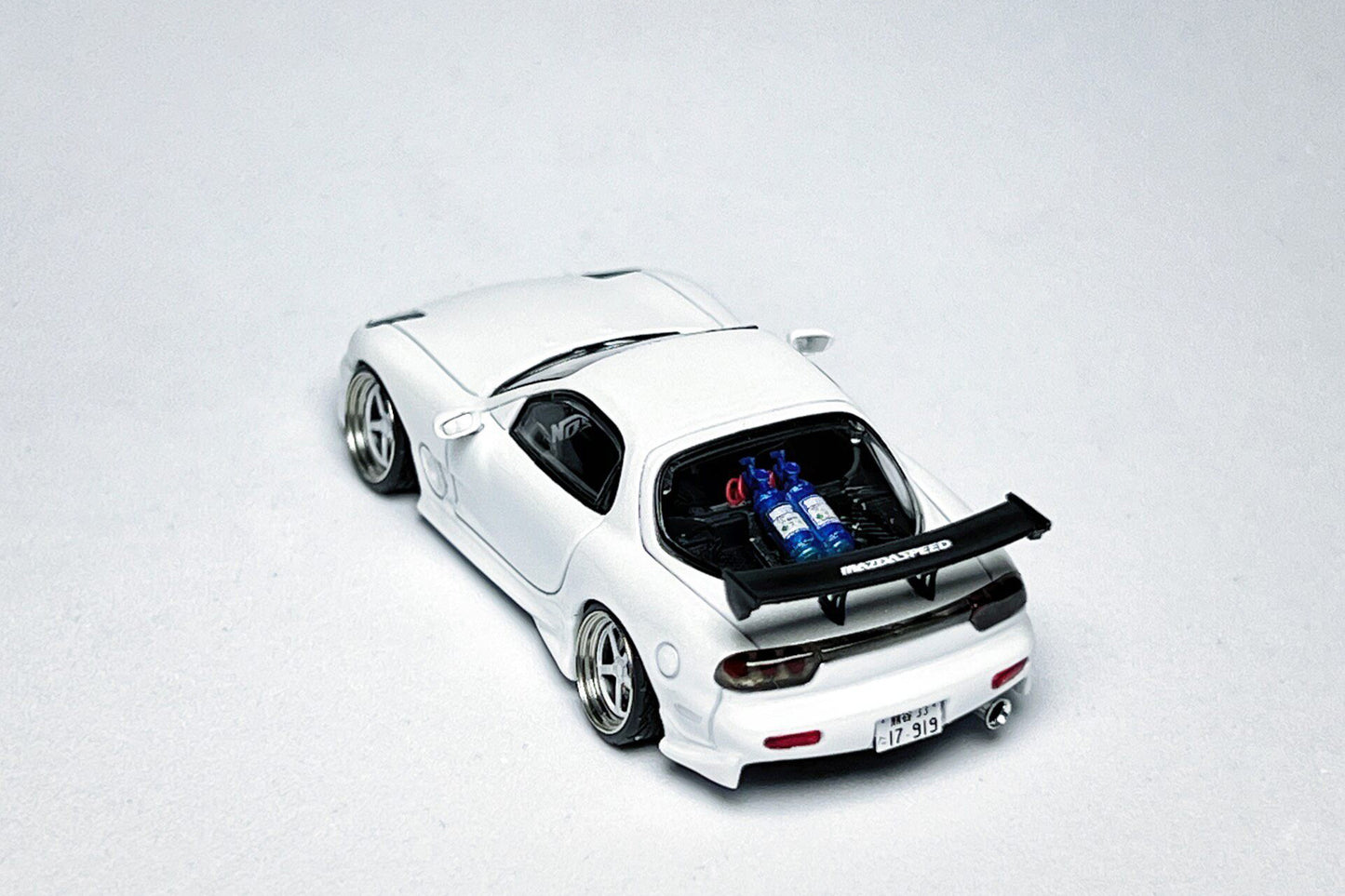 Custom 1:64 Mazda RX-7 VeilSide pearl white diecast model with visible text markings