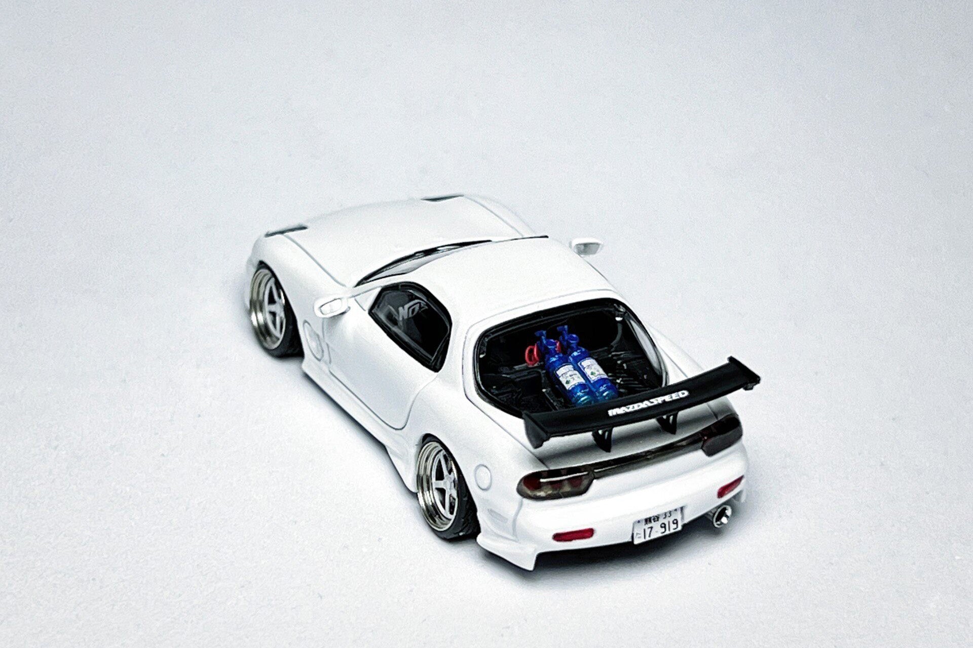 Custom 1:64 Mazda RX-7 VeilSide pearl white diecast model with visible text markings