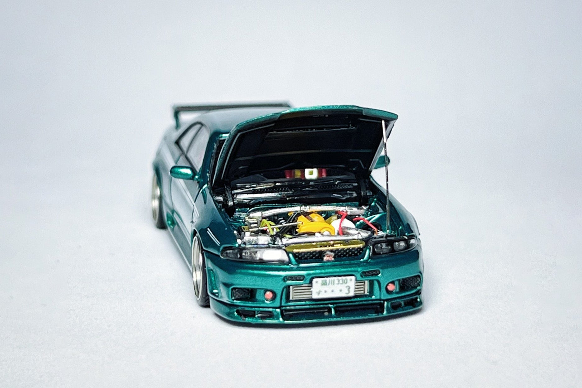Custom 1:64 Nissan Skyline GT-R R33 400R green diecast model with visible text markings
